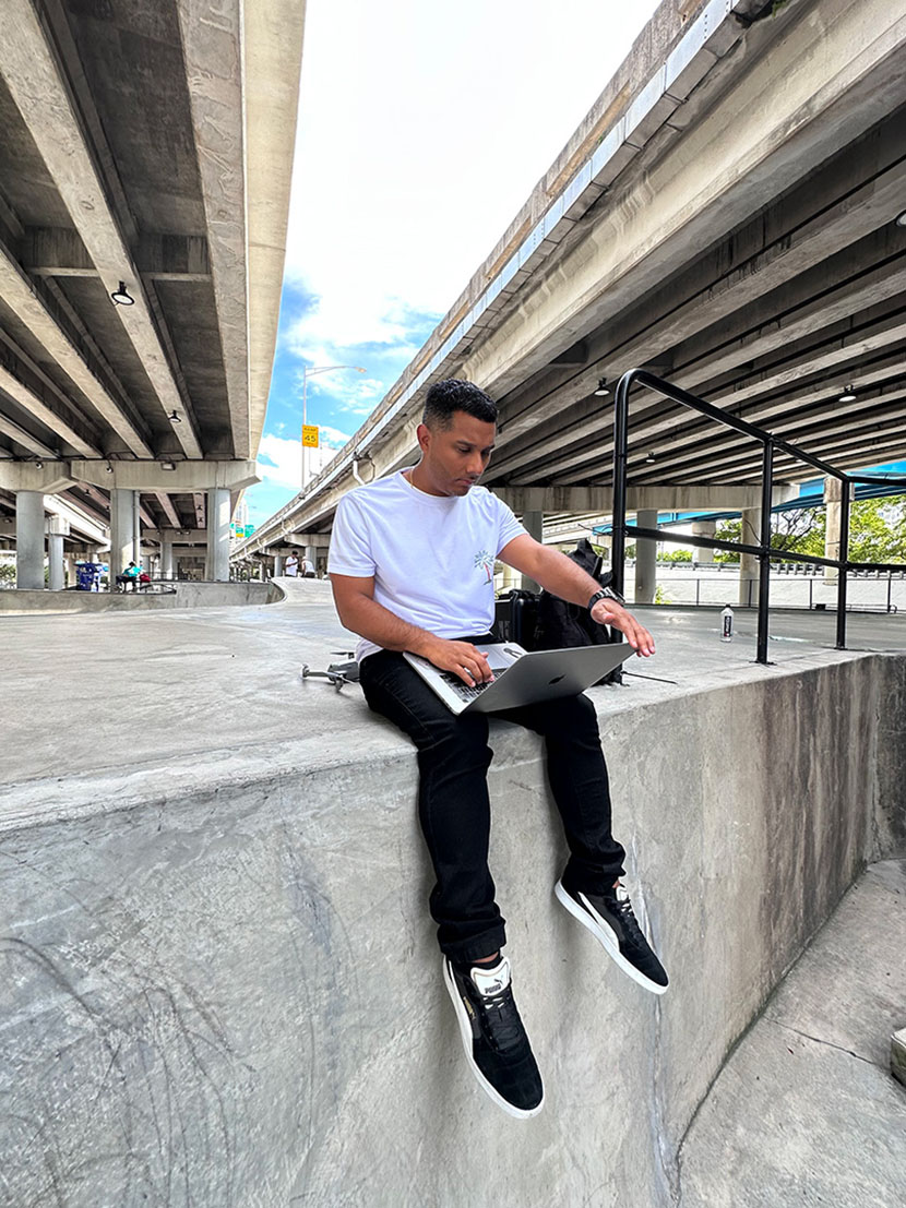 Image of Evan sitting on the edge of a concrete skate ramp at Lot 11 skatepark in Miami